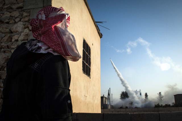A Rebel fighter watches a rocket headed for destruction in the city of Aleppo / Getty Images
