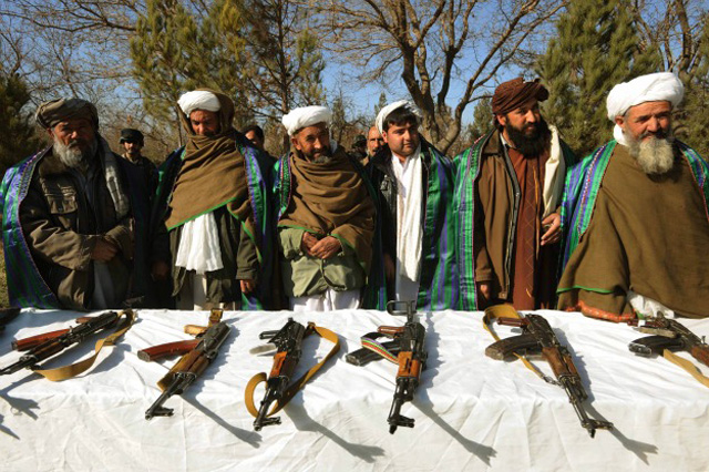 Taliban fighters stand near their weapons after they joined Afghanistan government forces during a ceremony in Herat (Getty Images)