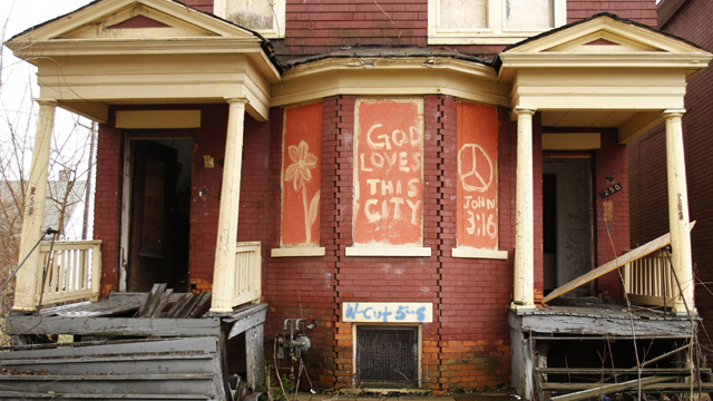 The words, "God Loves This City" are painted on the front of an abandoned home in Detroit  (Getty Images)