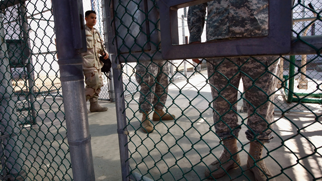 U.S. military personnel stand at fenced recreation areas inside the U.S. military prison for 'enemy combatants.' (Getty Images)