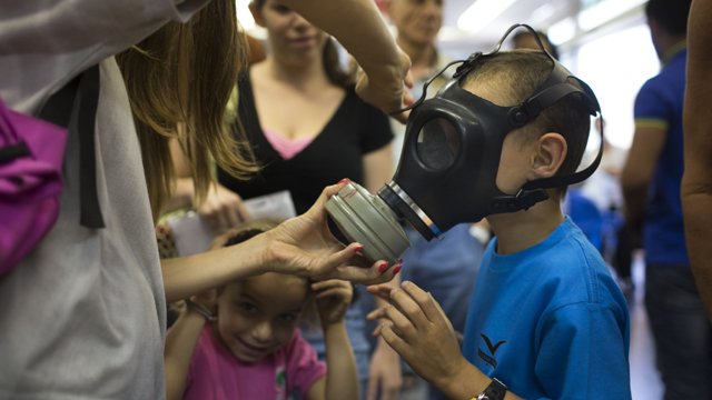 Israeli children learn to use a gas mask among raising concerns in the Middle East. (Getty)