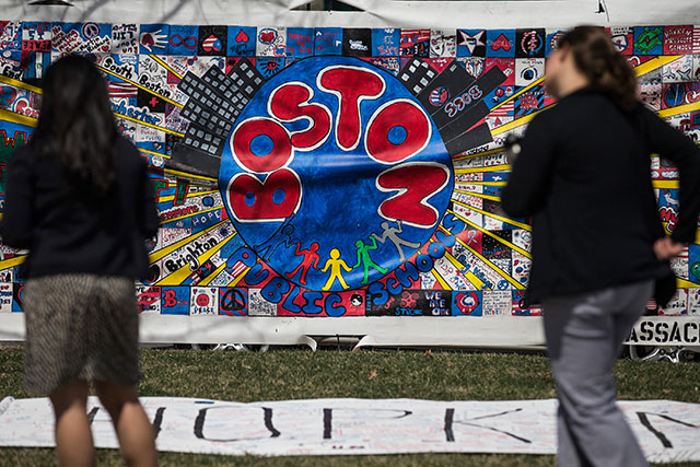 People look at a memorial quilt in honor of the Boston Marathon bombings on Monday, April 14. (Getty)
