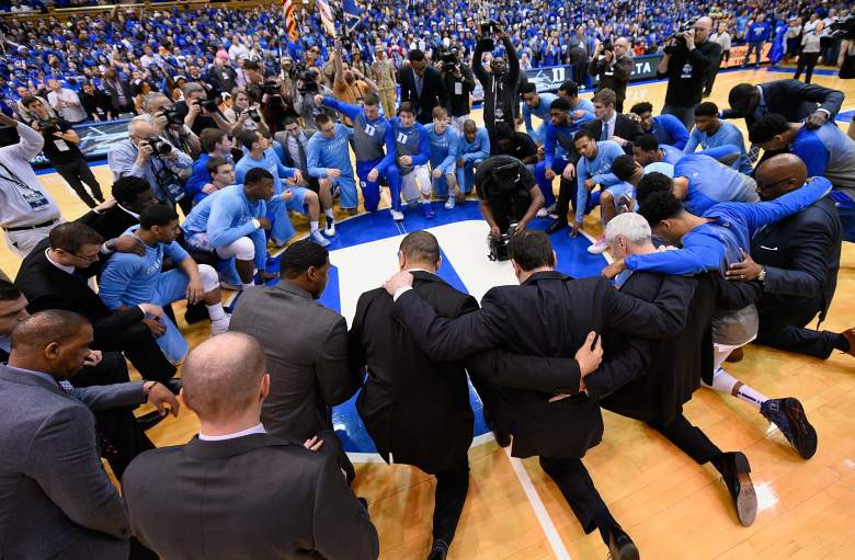 Players and coaches from both teams huddle at halfcourt for a moment of silence to mourn Dean Smith before the first meeting  last month. (Getty)