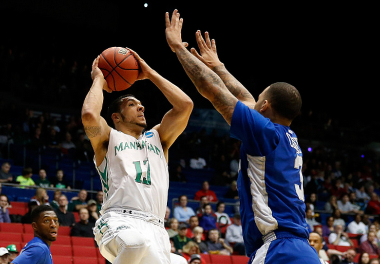 Emmy Andujar #13 of the Manhattan Jaspers goes up to the basket as Quinton Chievous #3 of the Hampton Pirates defends during the first round of the 2015 NCAA Men's Basketball Tournament at UD Arena on March 17, 2015 in Dayton, Ohio. (Getty)