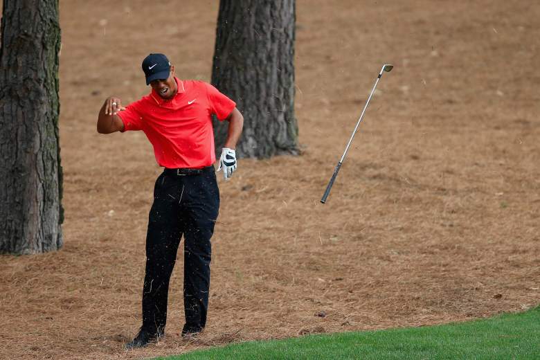Tiger Woods tosses his club after hitting a tree root on a shot Sunday. (Getty)