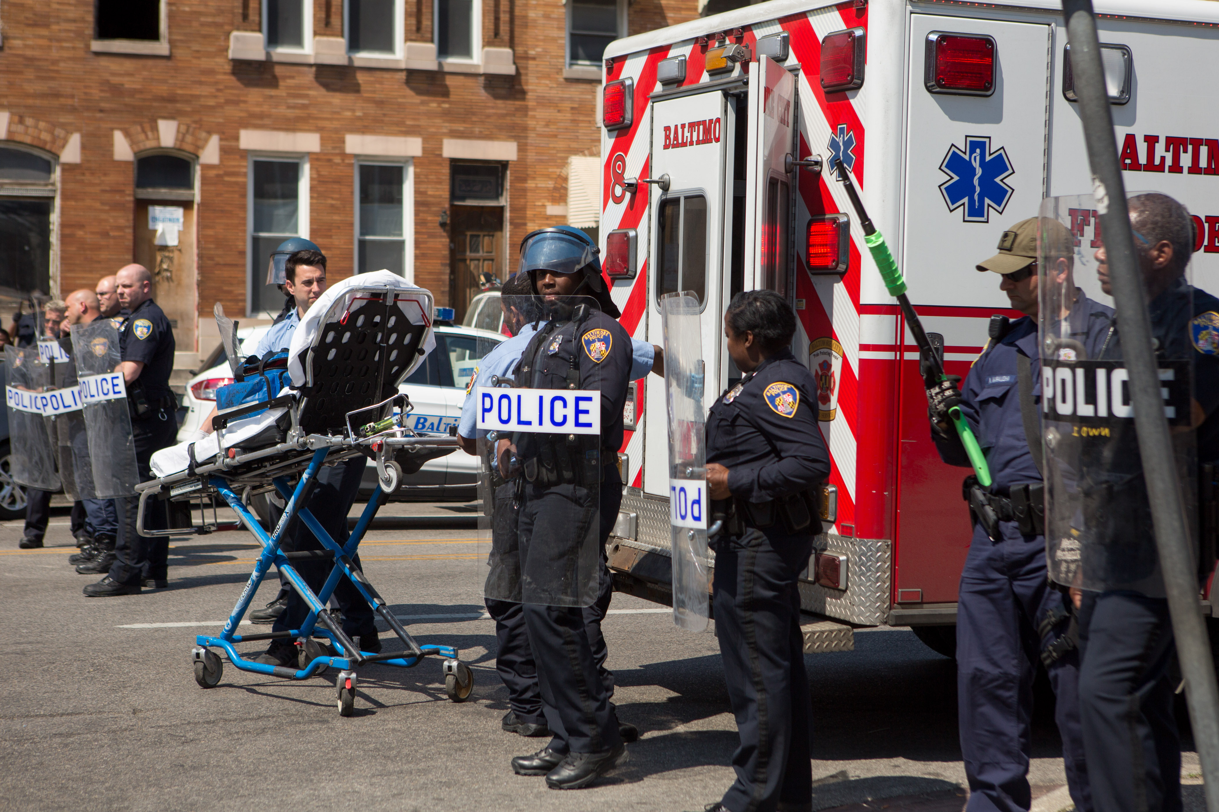 First responders roll a gurney on North Avenue in Baltimore. Police barricaded the block after initial reports indicated that a man had been shot by police, sparking anger in the crowd. Officials later reported that no one had been injured and the gun, carried by a man seen on a security camera, had discharged accidentally.  (Getty)