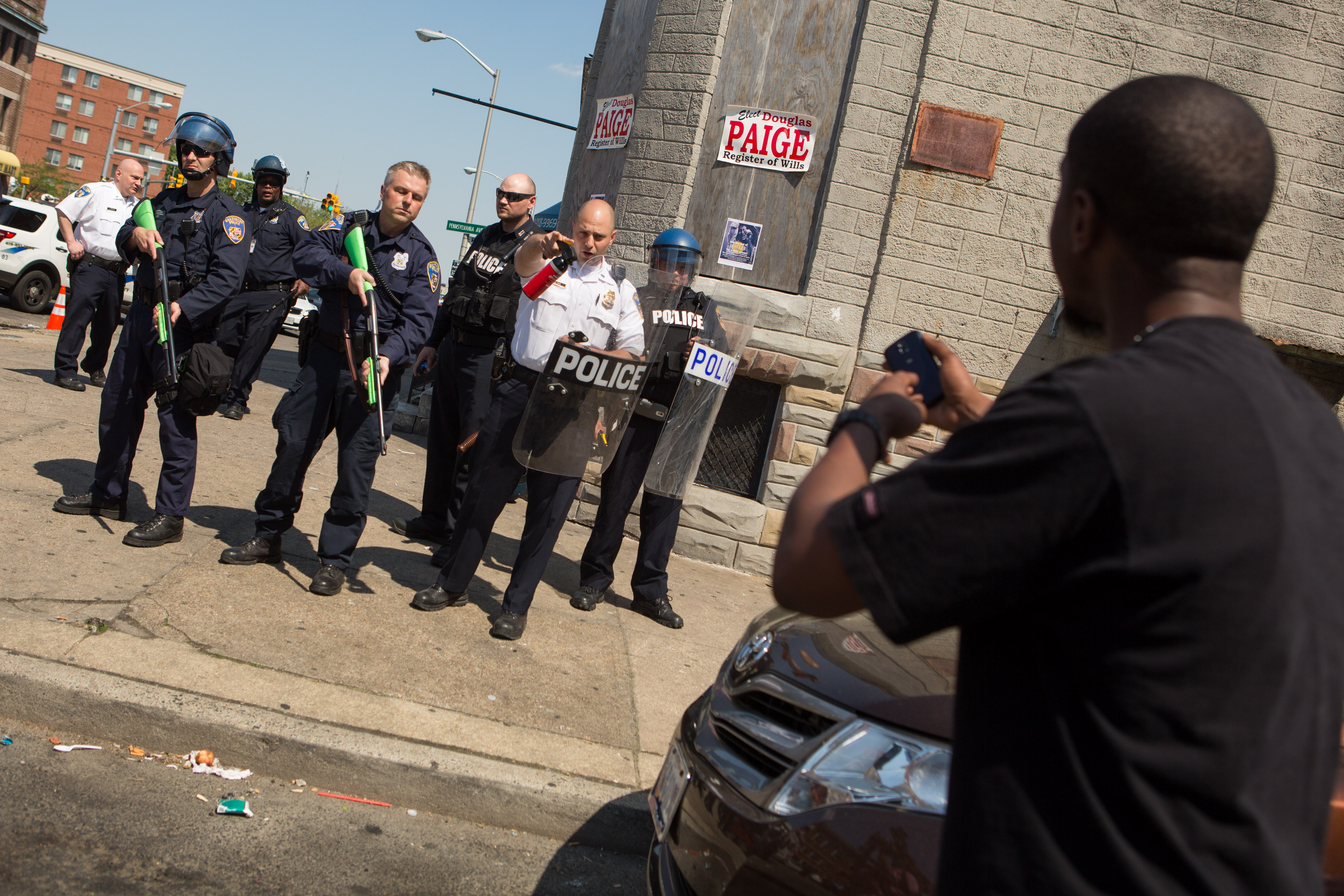 A man faces off with a line of police after a shot was fired during an arrest in Baltimore on North Avenue. (Getty)