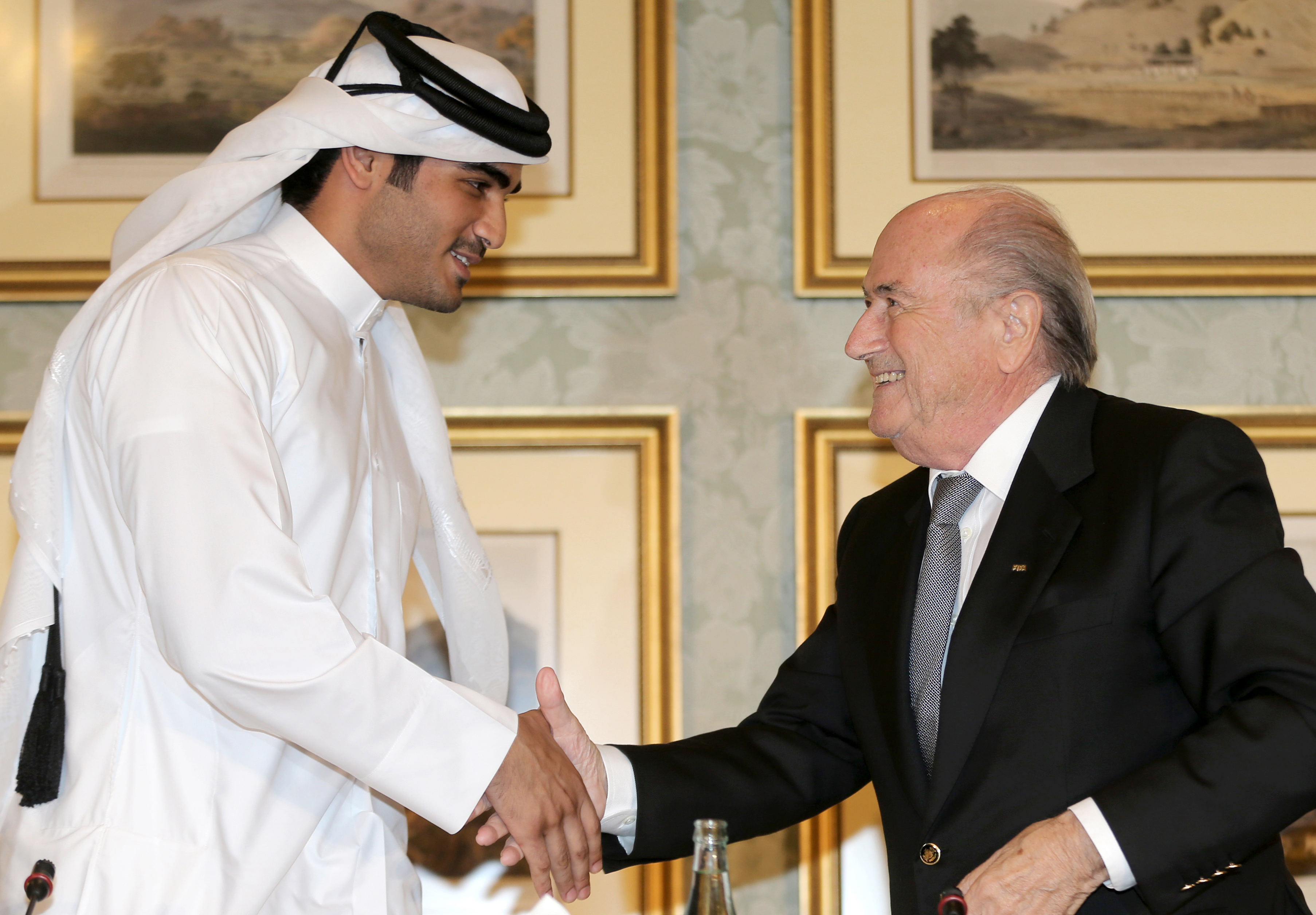 Chairman of the Qatar 2022 bid committee Sheikh Mohammed bin Hamad al-Thani, left, shakes hands with FIFA president Sepp Blatter during a press conference in the Qatari capital Doha on November 9, 2013.  (Getty)