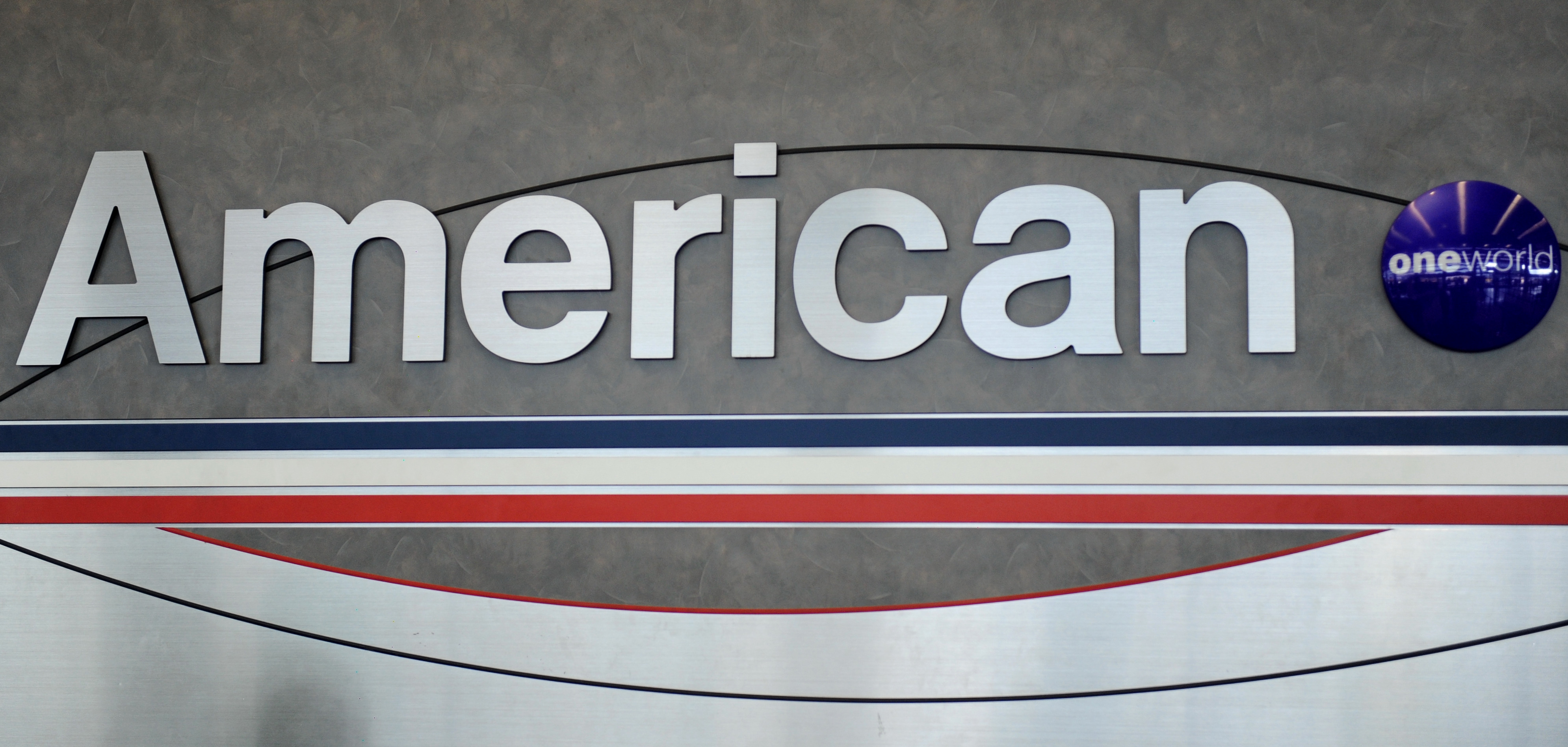 An American Airlines logo is seen behind a ticket counter at Chicago's O'Hare airport on August 13, 2013. (Getty)