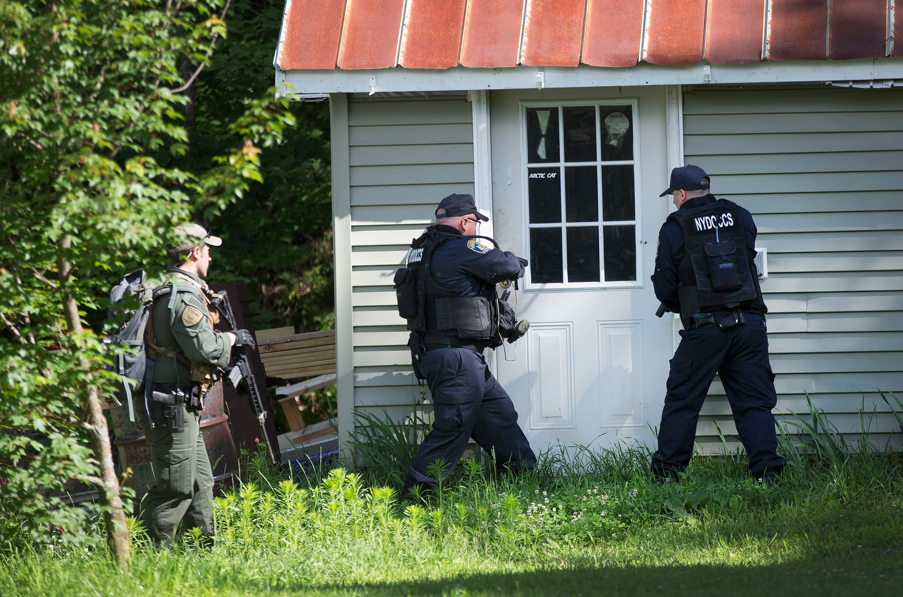 Officers search a house in Owls Head, New York. (Getty)
