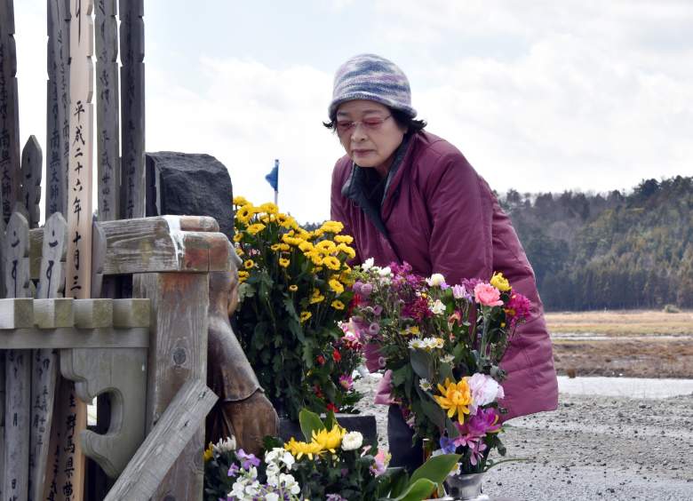 A relative of tsunami victims offers a flower bouquet at the altar at Namie, near the striken TEPCO's Fukushima Dai-ichi nuclear plant in Fukushima prefecture on March 11, 2015 on the fourth anniversary day of massive earthquake and tsunami hit northern Japan. The 9.0 magnitude earthquake in 2011 sent a huge wall of water into the coast of the Tohoku region, splintering whole communities, ruining swathes of prime farmland and killing nearly 19,000 people. (Getty Images)