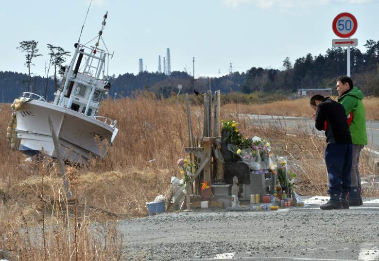 Two men offer prayers before the altar at Namie, near the striken TEPCO's Fukushima Dai-ichi nuclear plant in Fukushima prefecture on March 11, 2014 on the third anniversary day of massive earthquake and tsunami hit northern Japan. The 9.0 magnitude earthquake in 2011 sent a huge wall of water into the coast of the Tohoku region, splintering whole communities, ruining swathes of prime farmland and killing nearly 19,000 people. (Getty Images)