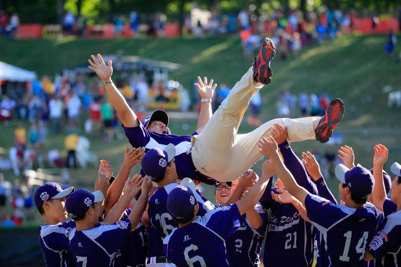 SOUTH WILLIAMSPORT, PA - AUGUST 24: Members of Team Asia-Pacific (L) throw an assistant coach in the air following their 8-4 win over the Great Lakes Team from Chicago, Illinois to win the Little League World Series Championship game at Lamade Stadium on August 24, 2014 in South Williamsport, Pennsylvania. (Photo by Rob Carr/Getty Images)
