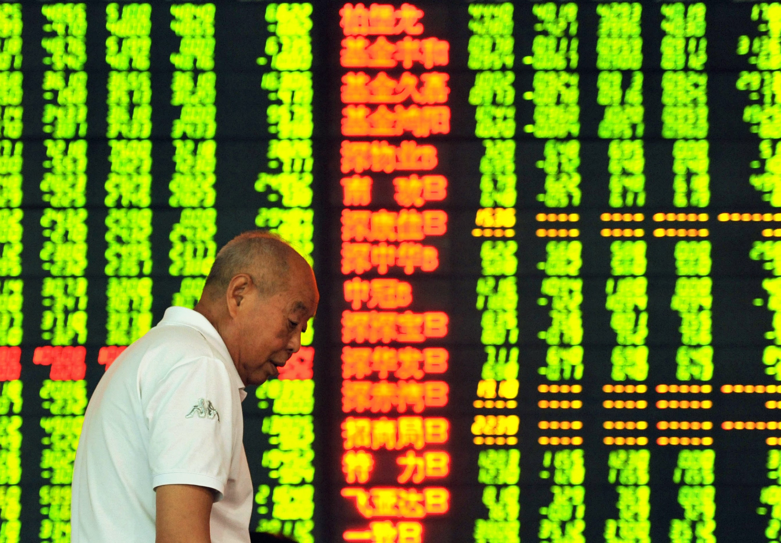 An investor stands in front of a screen showing share prices at a securities firm in Hangzhou, in eastern China's Zhejiang province. (Getty)