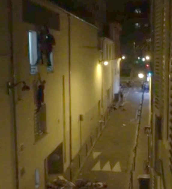 A screengrab from a video shot by Le Monde journalist Daniel Psenny shows victims hanging from a window after escaping the Bataclan theater. (Daniel Psenny/Le Monde)