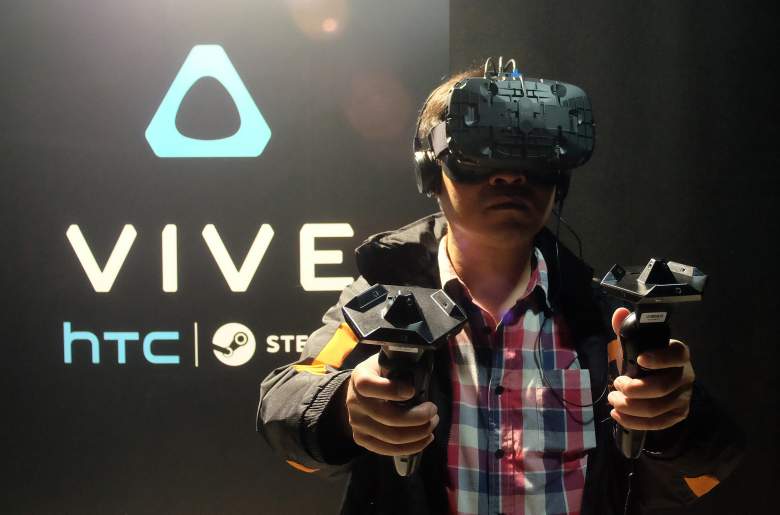 A fan wears a HTC Vive headset and holds two sensors during a promotional event held by HTC in Taipei on December 15, 2015.  Smartphone maker HTC unveiled to Taiwanese gamers its virtual reality headset for the first time, as the company pins hopes on the new product to help revive its struggling business.  AFP PHOTO / Sam Yeh / AFP / SAM YEH        (Photo credit should read SAM YEH/AFP/Getty Images)