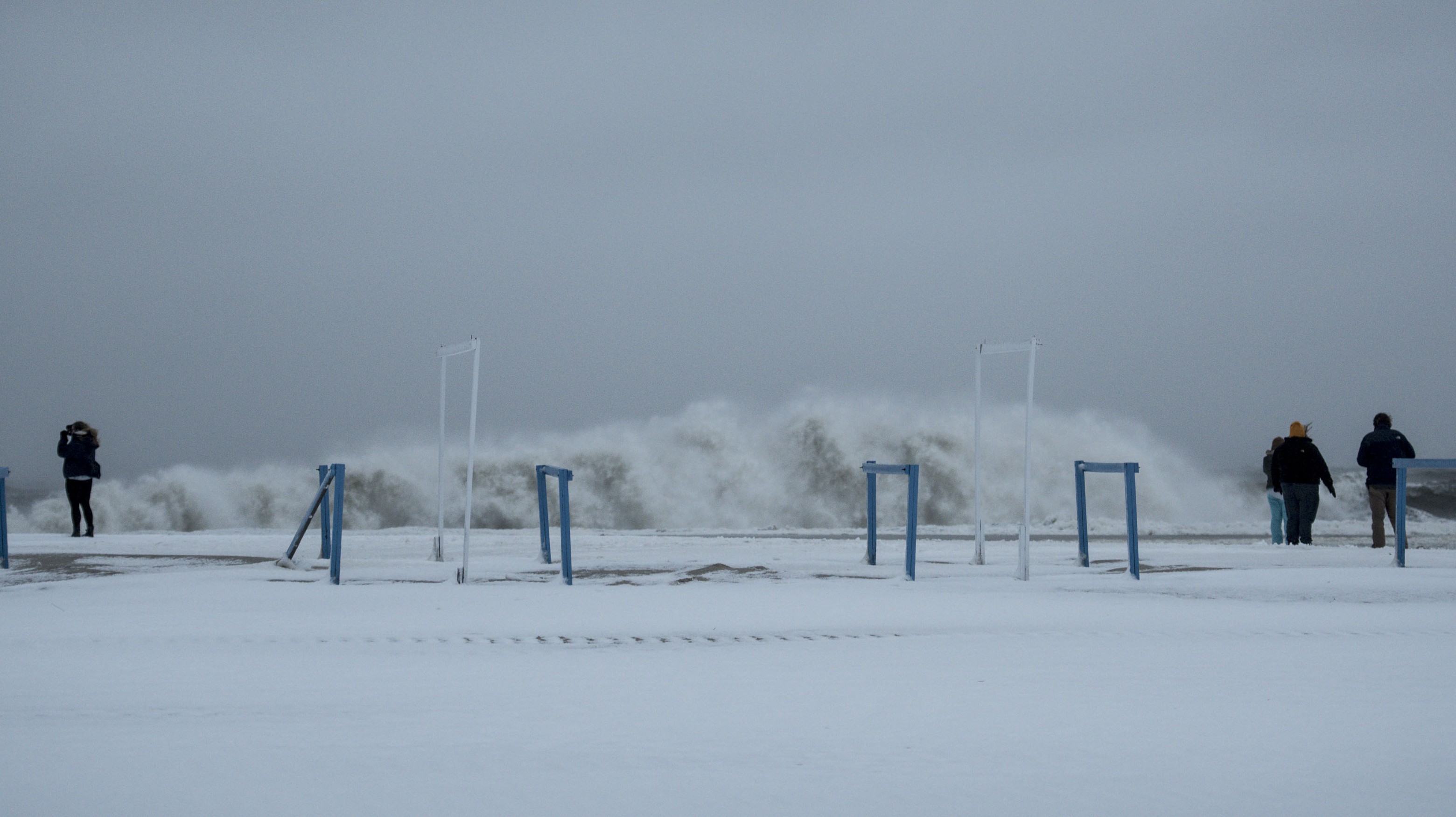 People take pictures on the beach as a storm hits the area on January 23, 2016 in Cape May, New Jersey. (Getty)
