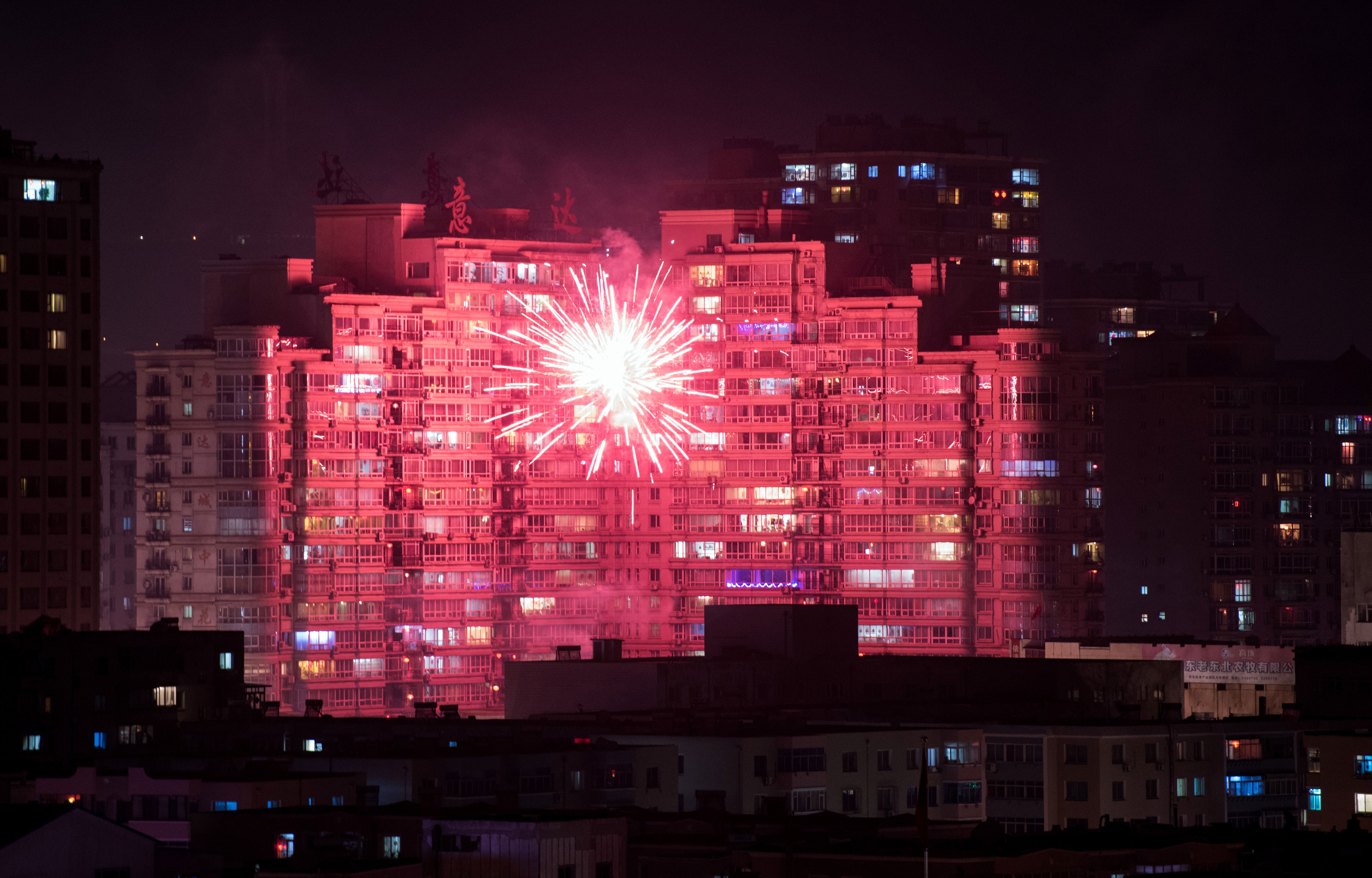 Fireworks illuminate buildings of the Chinese border town of Dandong as people celebrate the eve of the Lunar New Year. (Getty)