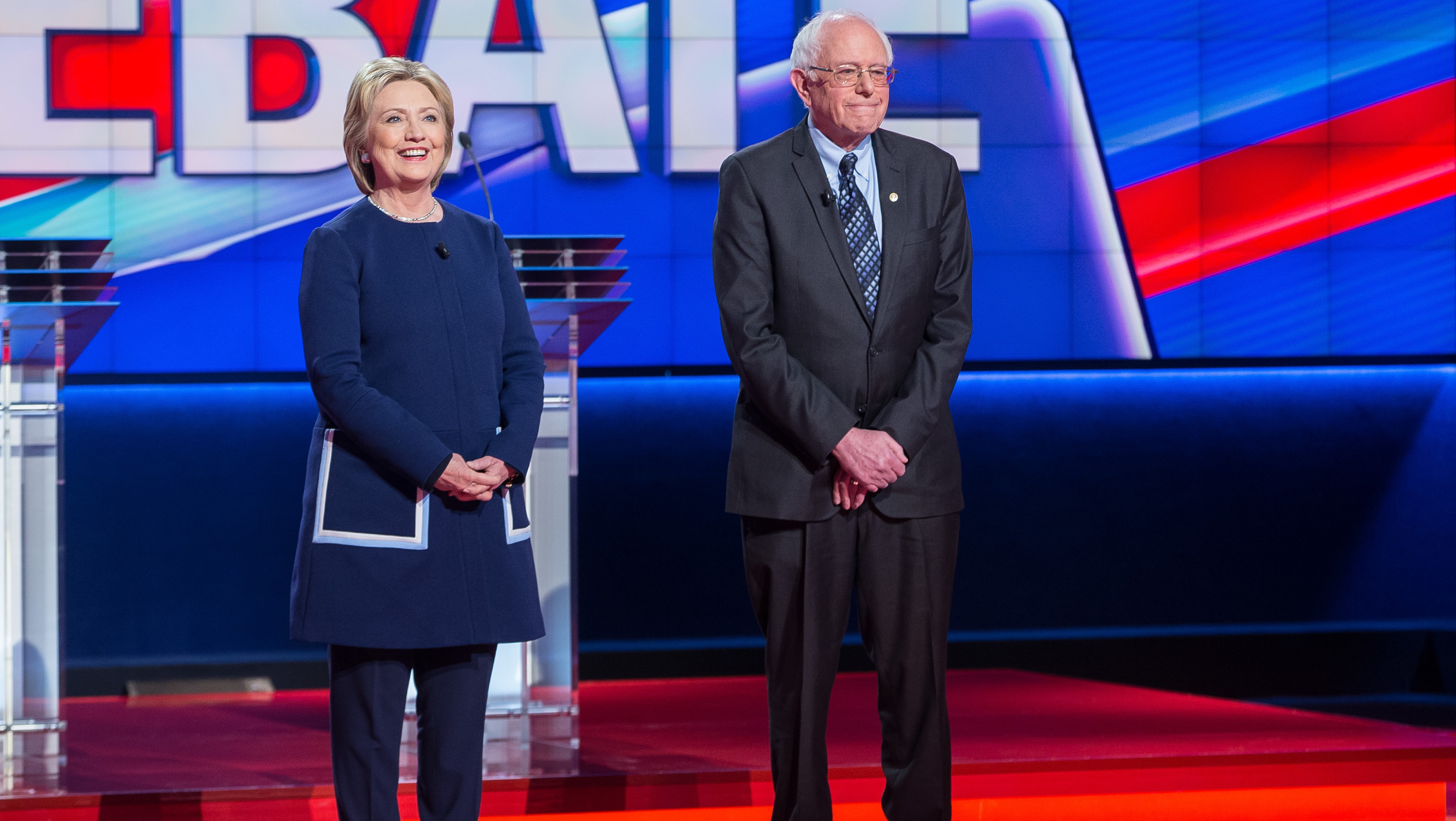 Democratic presidential candidates Hillary Clinton and Bernie Sanders stand before the Democratic Debate in Flint, Michigan, March 6, 2016. (Getty)