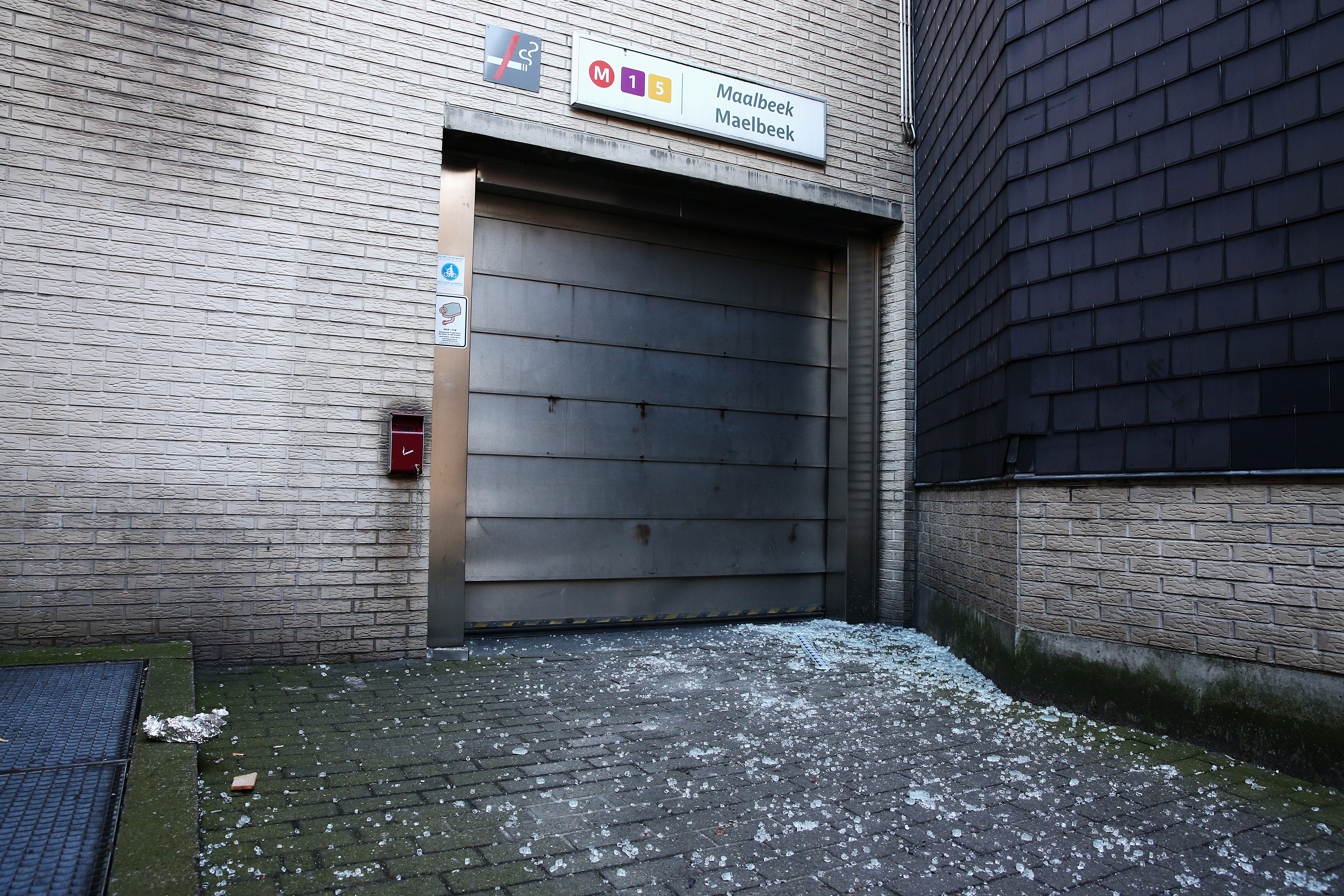 Broken glass is seen outside an entrance to Maelbeek metro station. (Getty)