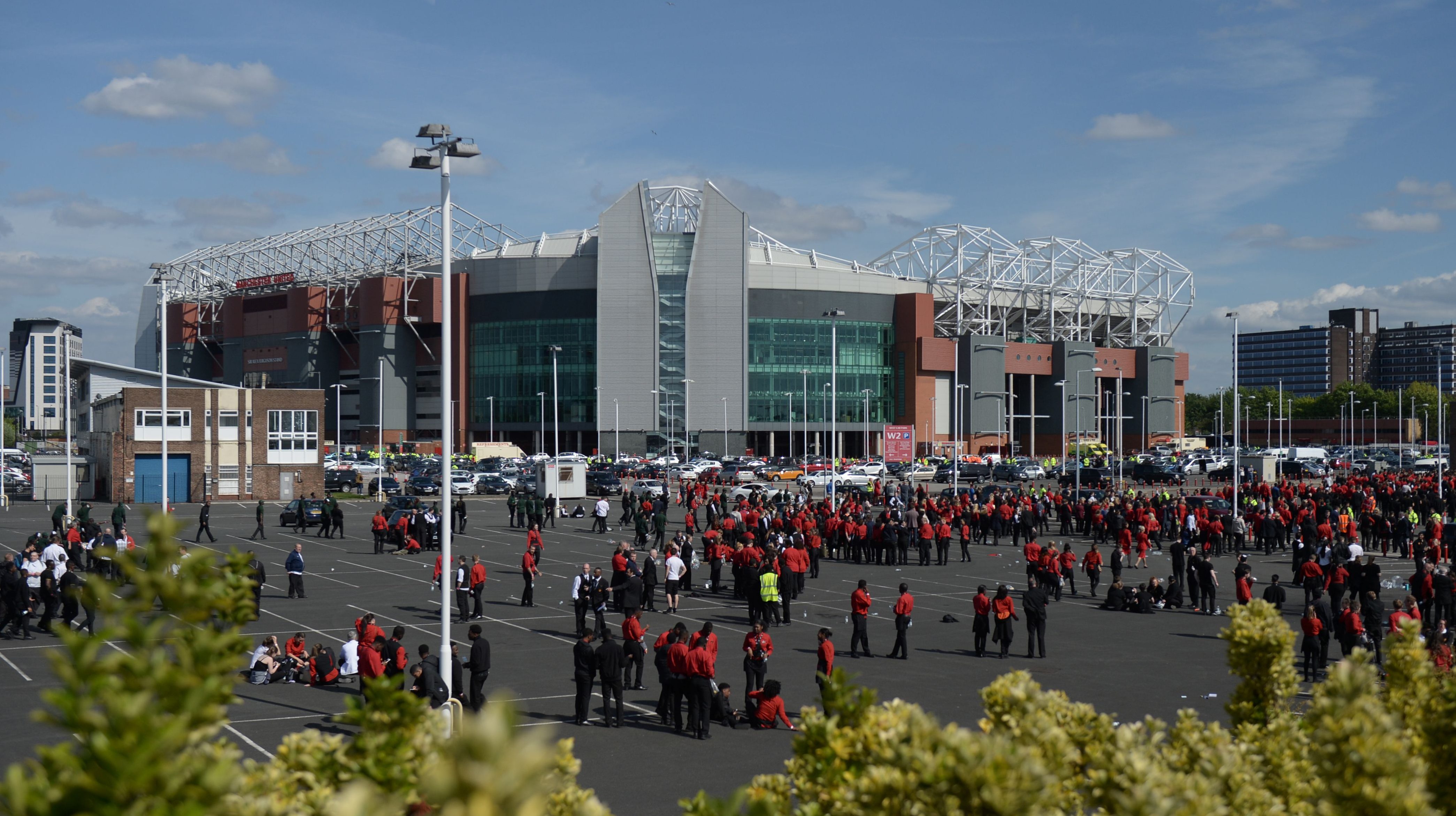 Old Trafford stadium workers stand in a car park outside the stadium in Manchester, north west England, on May 15, 2016, after the English Premier League football match between Manchester United and Bournemouth was abandoned. (Getty)