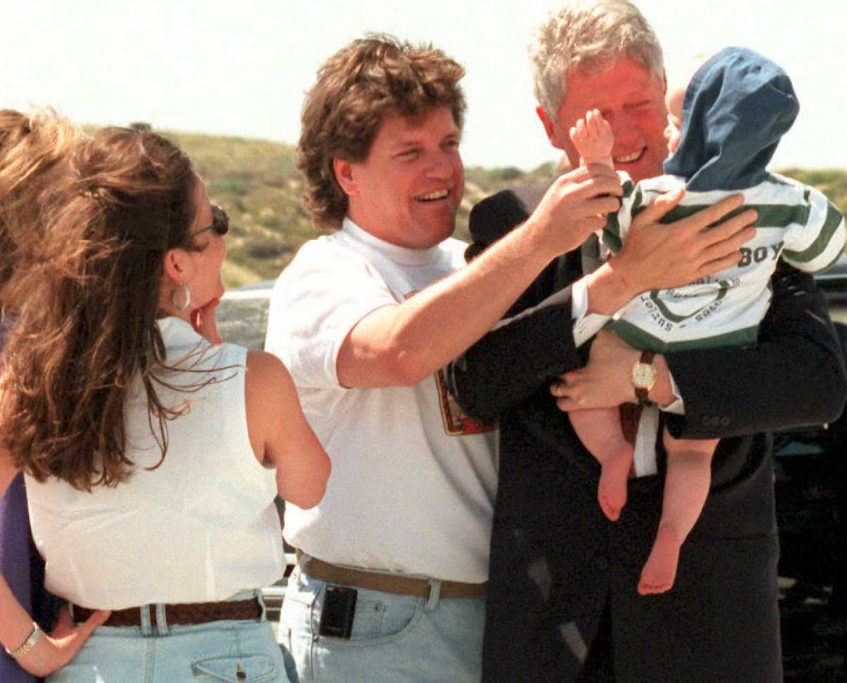President Bill Clinton holds his one-year-old nephew Tyler, son of the president's brother Roger Clinton, center, before boarding Air Force One on April 9, 1995 at Los Angeles International Airport. (Getty)