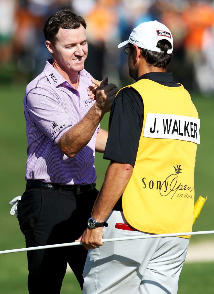 Jimmy Walker celebrates with Andy Sanders on the 18th green after winning the final round of the Sony Open In Hawaii at Waialae Country Club on January 18, 2015 in Honolulu, Hawaii. (Getty)