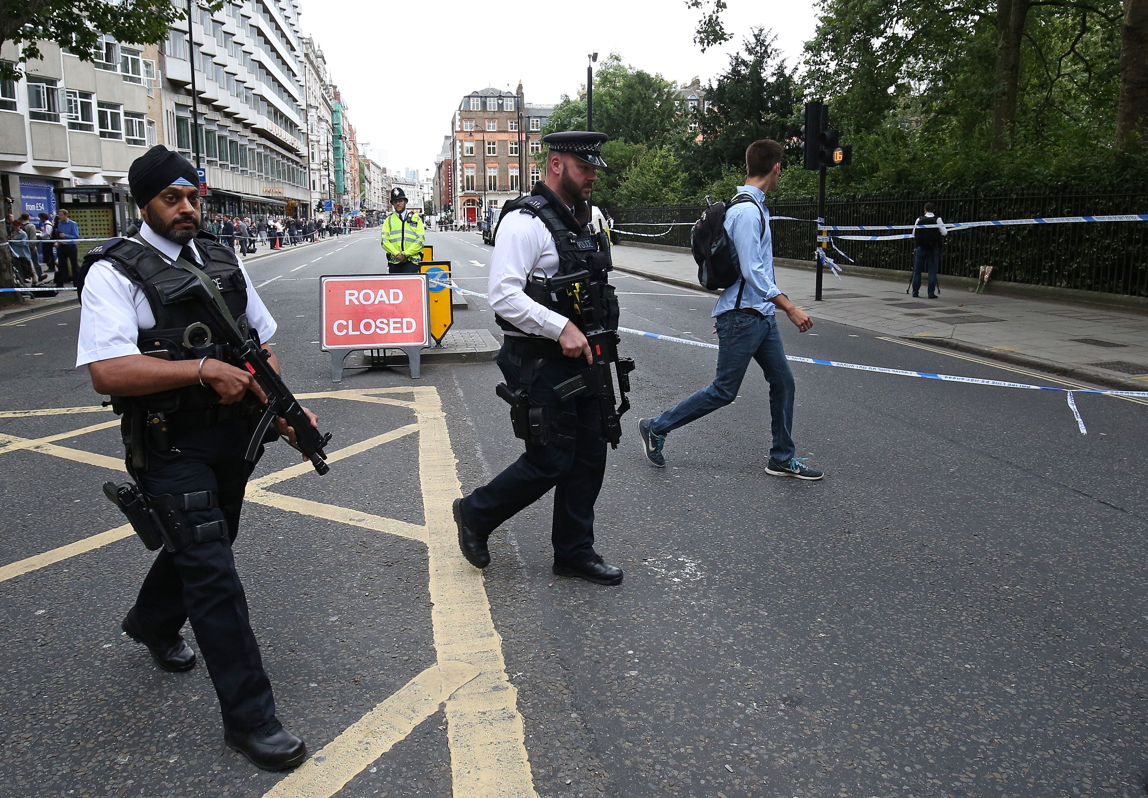 Armed police personnel walk past a crime scene in London's Russell Square on August 4, 2016. (Getty)