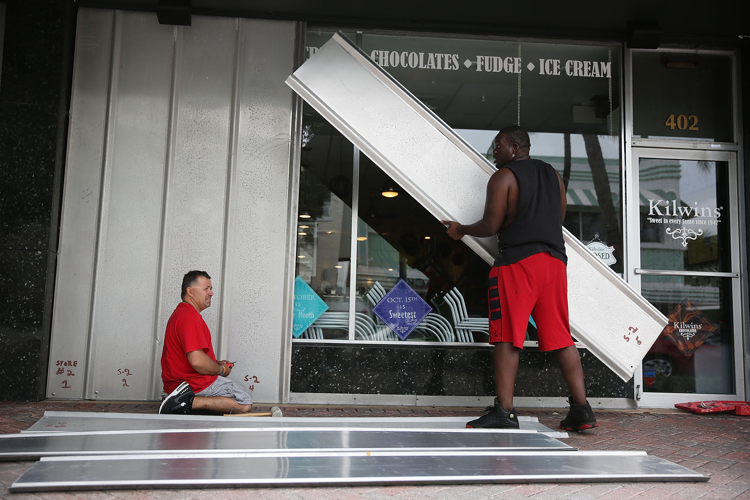 Jason Brock and Kevin Hunter put up hurricane shutters in front of a business as Hurricane Matthew approaches the area on October 6, 2016 in Delray Beach, Florida. (Getty)