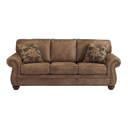 brown faux leather sofa with pillows