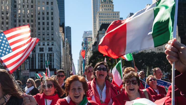 Attendees wave flags at the NYC Columbus Day Parade