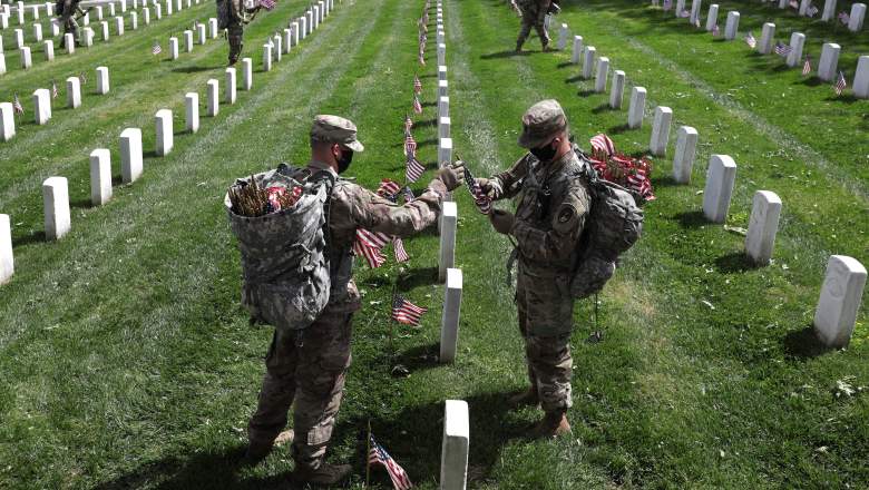 Soldiers from the 3rd Infantry Regiment, also called the "Old Guard," place U.S. flags in front of every grave site ahead of the Memorial Day weekend in Arlington National Cemetery