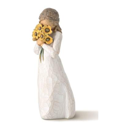Light colored figurine of woman with sunflowers