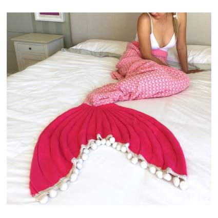 Woman with pink mermaid knit blanket