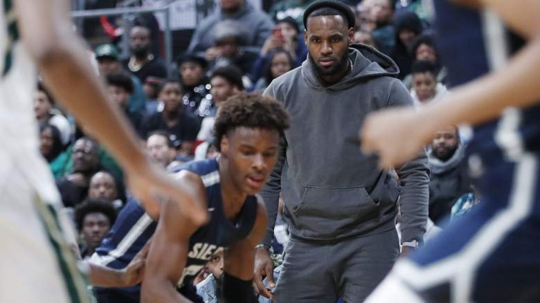 Bronny James, center, dribbles for Sierra Canyon High School as his father, LeBron James, looks on.