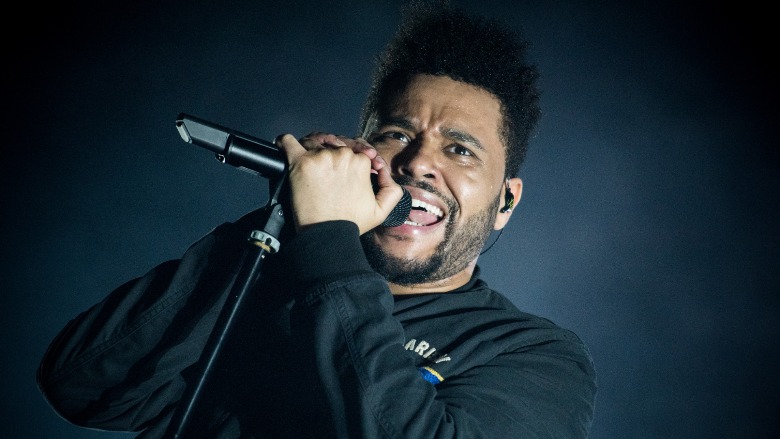 The Weeknd holding a microphone.