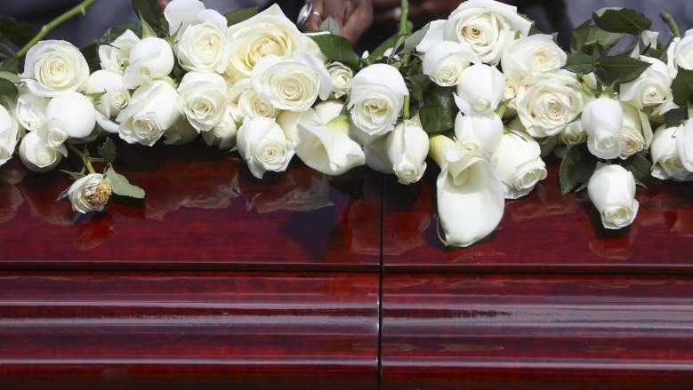 Flowers are shown on a casket at a graveside service
