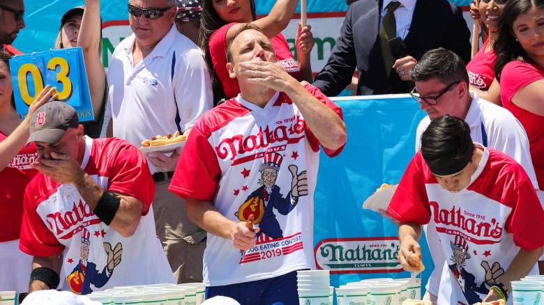 Joey Chestnut (C) eats during the men's hot dog eating contest on July 4, 2019