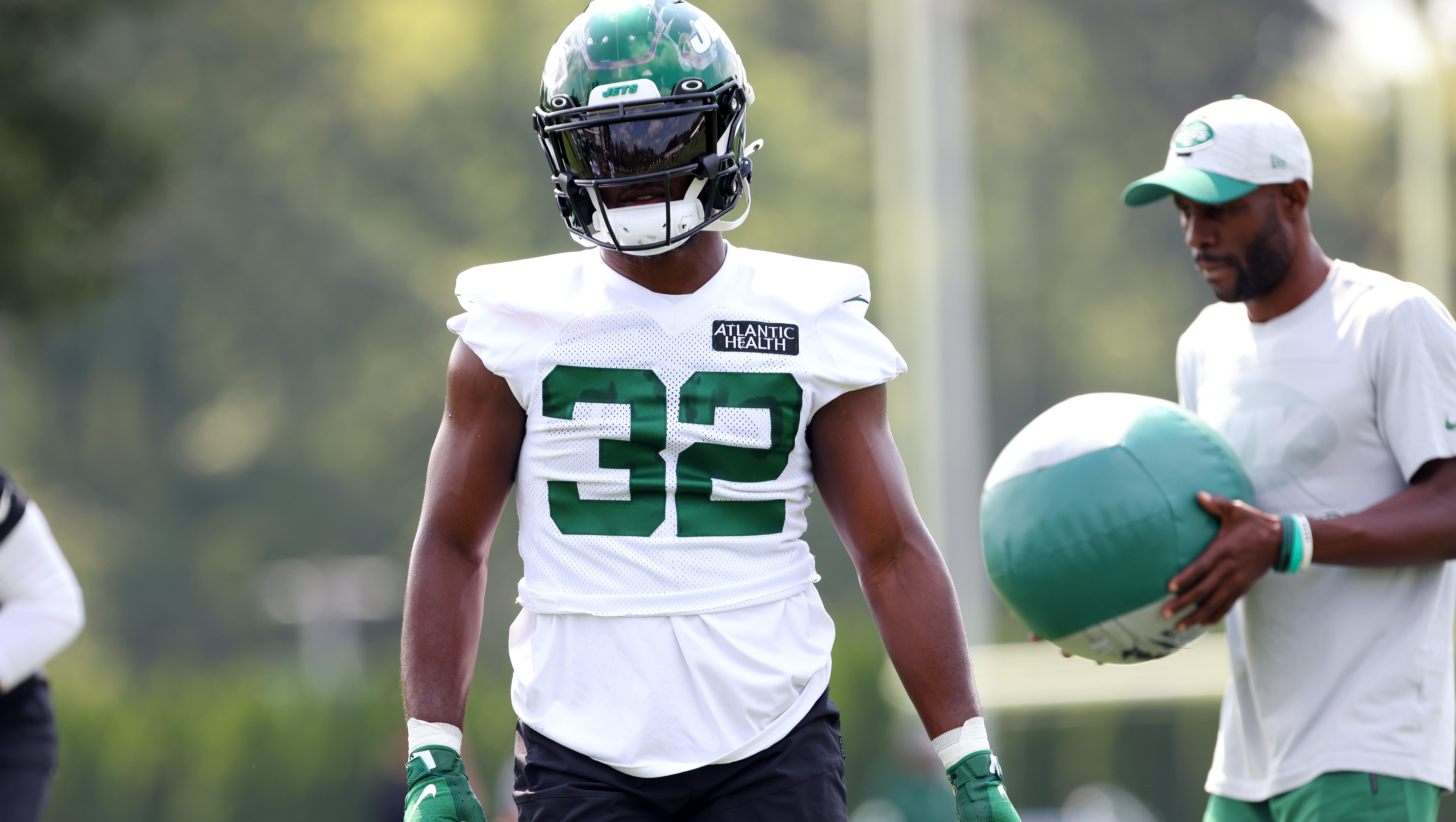 New York Jets' Michael Carter , right, runs the ball into the end