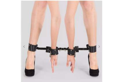 Arms and legs strapped into black leather leg spreading bar