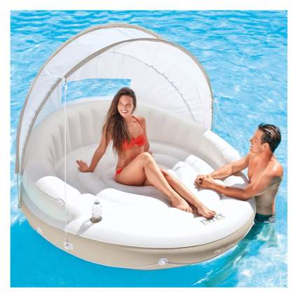 White pool canopy float with swimming couple