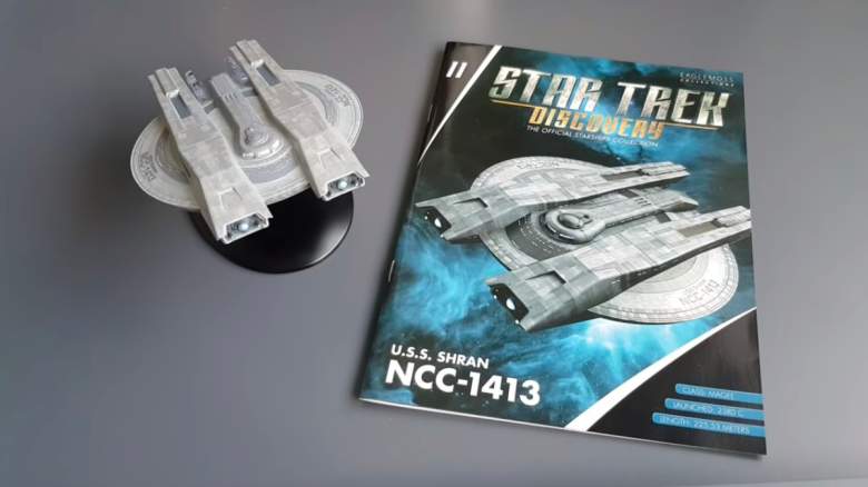Model of the USS Shran next to a booklet about the model