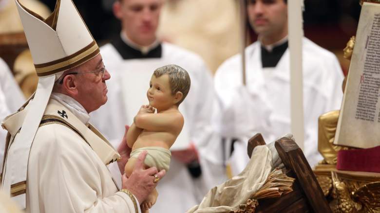 Pope Francis carries the baby Jesus as he attends the Christmas night mass at the St. Peter's Basilica