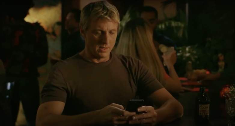 Johnny writes out Facebook message in Cobra Kai