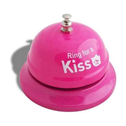 pink hand bell that says ring for a kiss