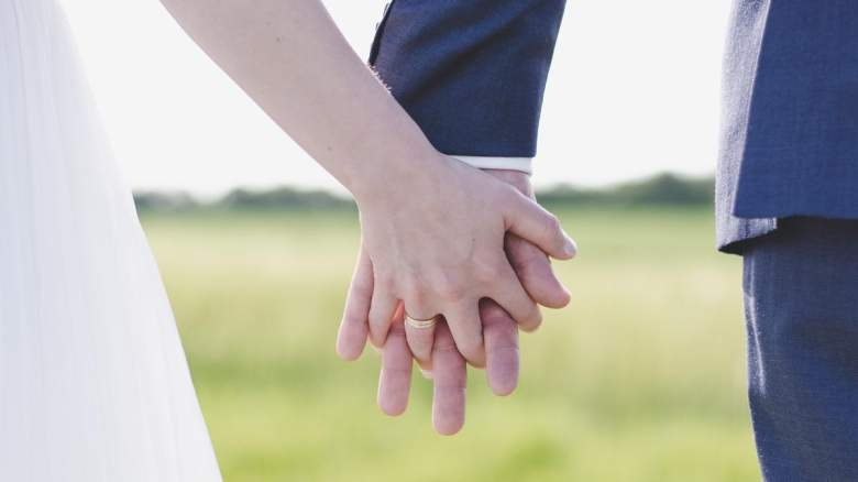 A bride and groom holdl hands