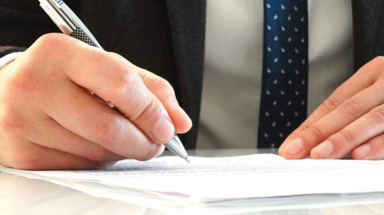 A man signing documents.