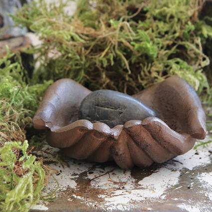 Cast Iron hands offering dish with moss and stone