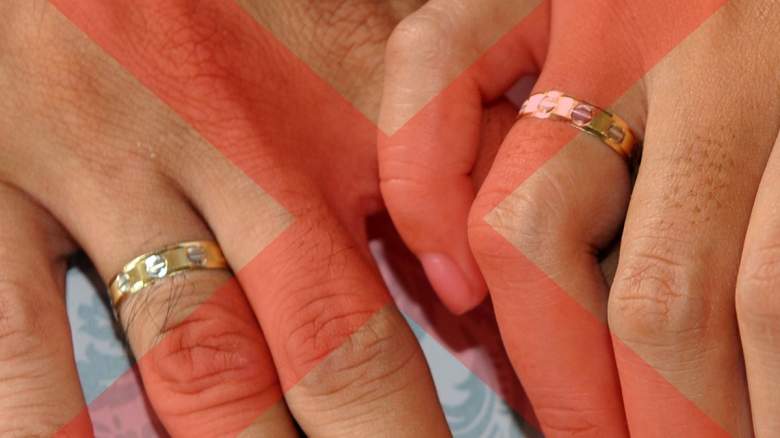 A couple holding hands with engagement rings