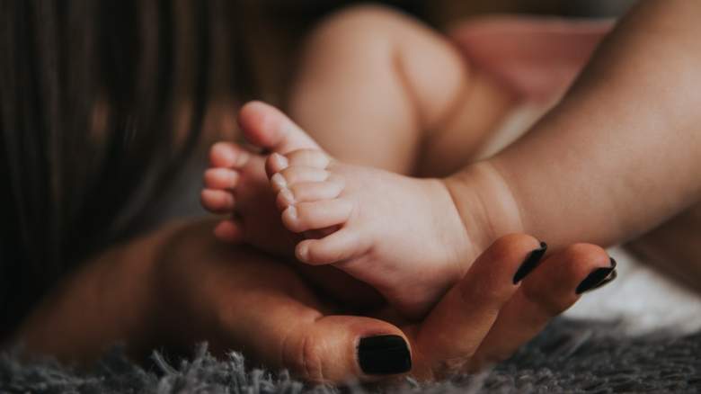 A mother holds her newborn's feet